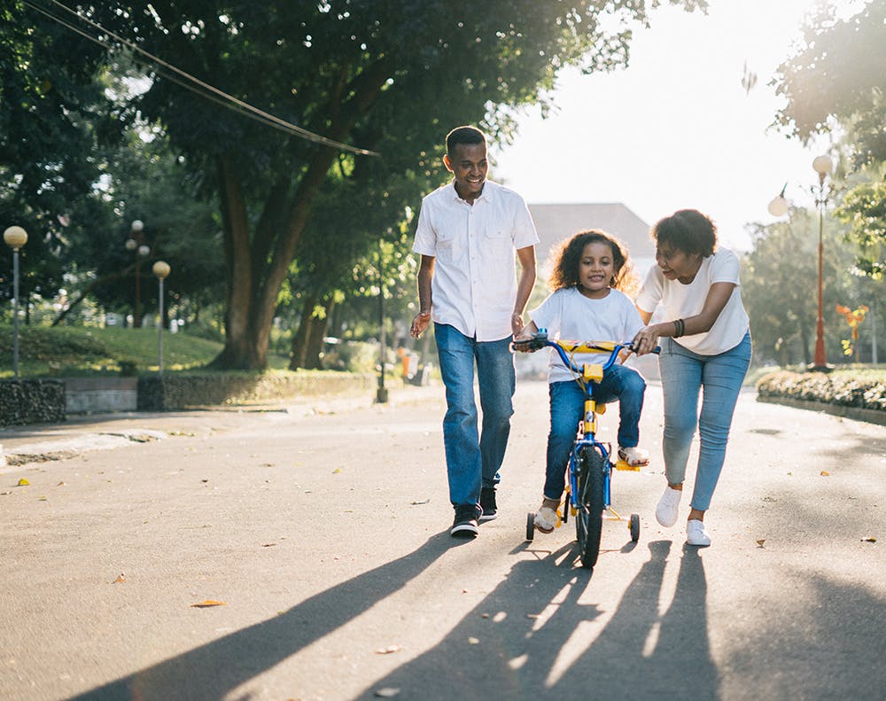 family learning how to ride a bike