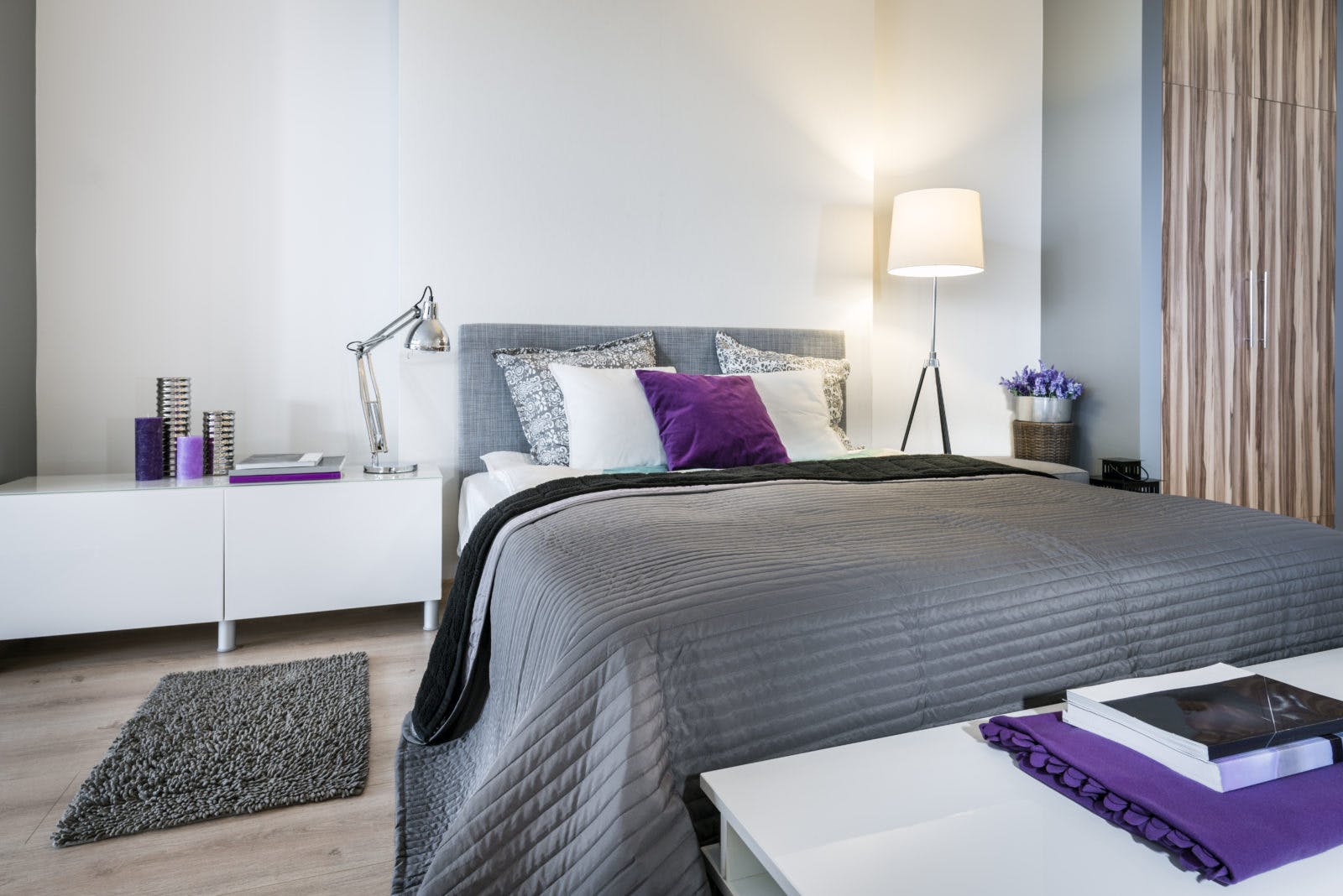 Bedroom interior with gray bed and white walls